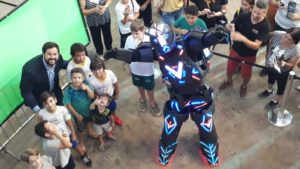 Prefeito Luiz Fernando Machado ao lado de crianças e robô. 
