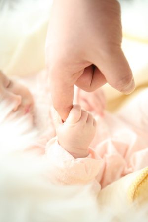Foto de bebê segurando a mão do pai