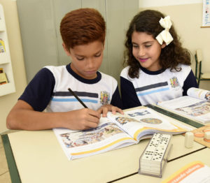 Foto de menino e menina, estudantes, que ganharam prêmio em Olimpíada de Matemática