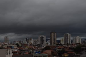 foto da cidade de São Paulo, ao fundo edifícios com o céu cheio de nuvens cinzas carregadas