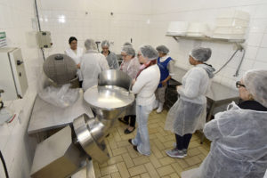 Pessoas com toucas em cozinha industrial