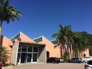 Fachada da Biblioteca Municipal de Jundiaí, prédio com árvores e carros estacionados